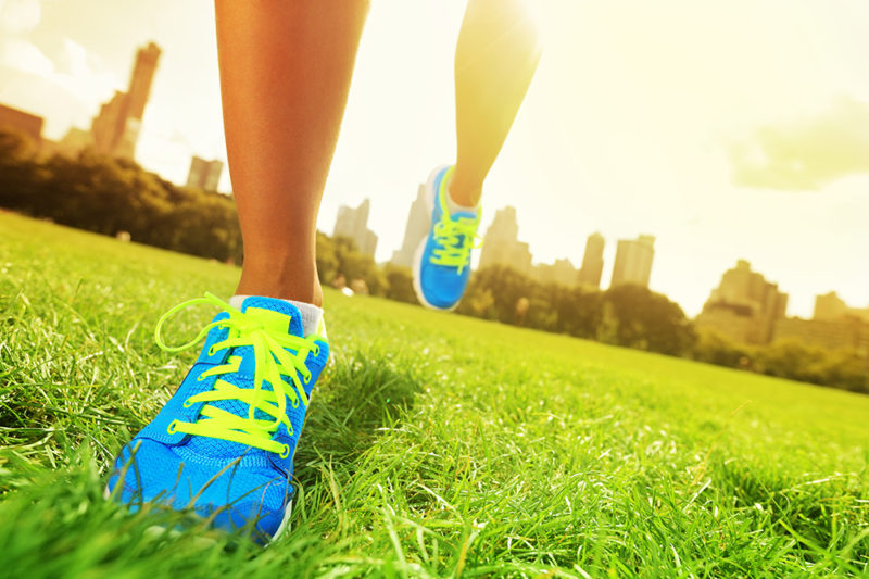 Runner - running shoes closeup of woman barefoot running shoes. Female jogging in Central Park, New York City.